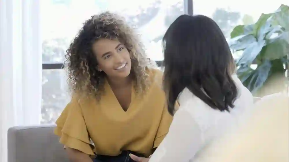 Two women having a conversation in a brightly lit room